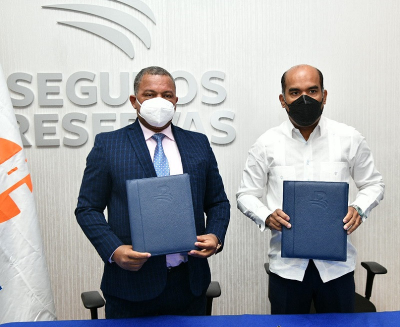 Rafael Arias, director del INTRANT y Josu00e9 Rojas vicepresidente ejecutivo de Seguros Reservas durante el acto de firma