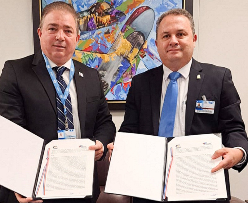 Hector Porcella, del IDAC y Juan Carlos Trabanino Aguirre, de COCESNA, muestran el acuerdo