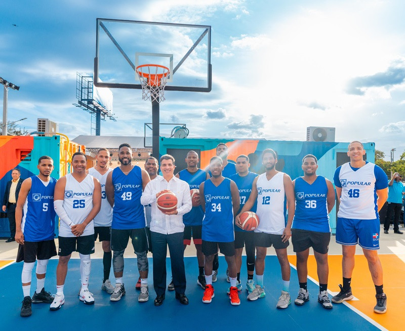 El presidente ejecutivo del Banco Popular, señor Christopher Paniagua, junto a empleados del equipo de baloncesto de la institución.